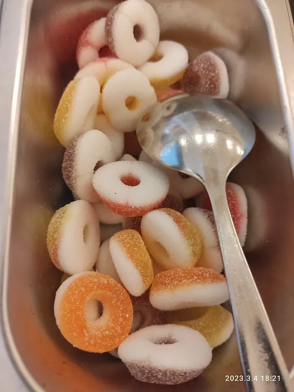 Mesas de dulces de distintos colores y estilos, con frascos, charolas y letreros, montadas en fiestas y en tiendas